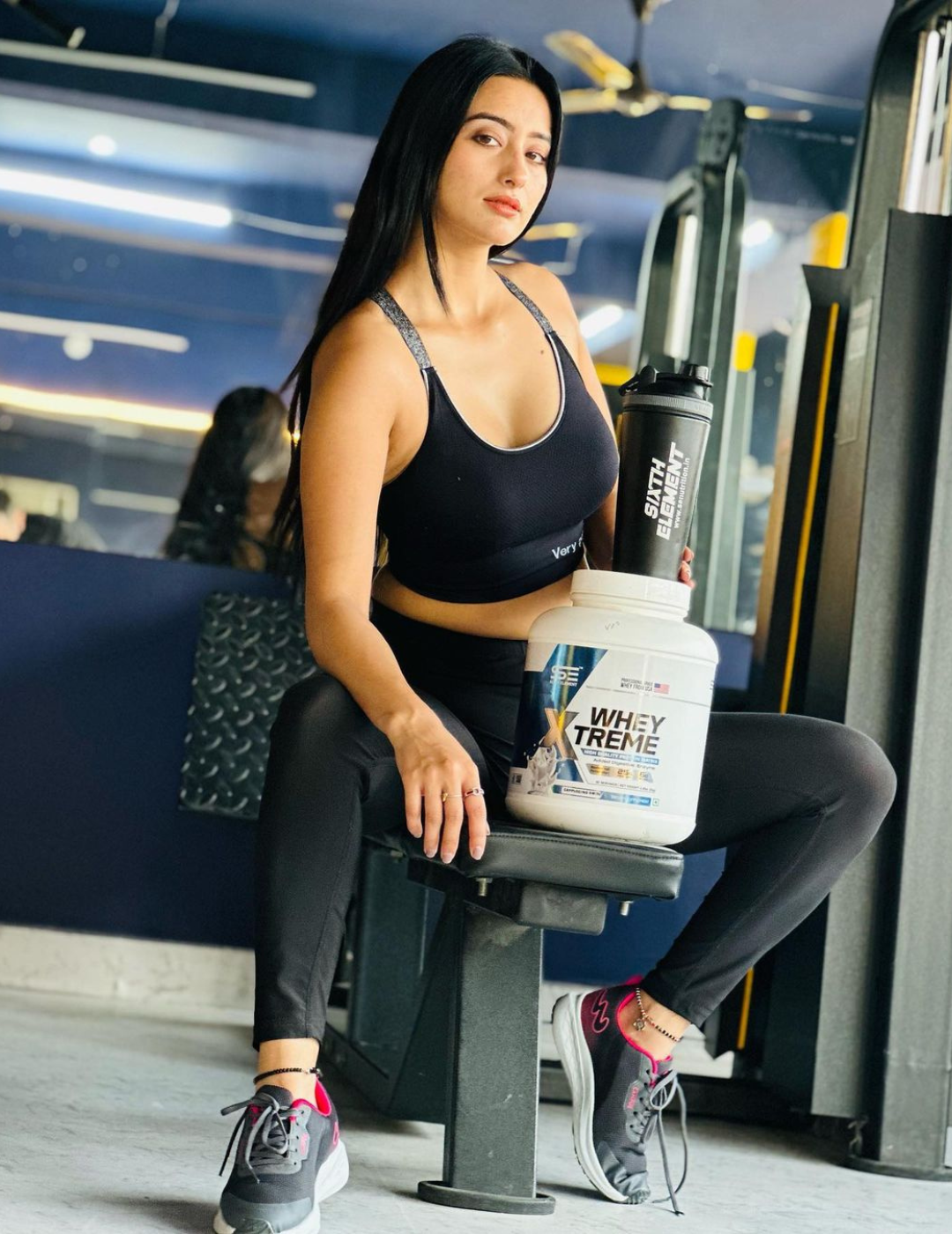 An image showing a bodybuilder women showcasing Xtreme whey protein powder jar